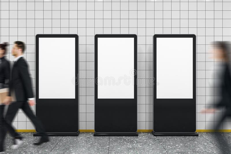 Tomma reklamskärmar på tunnelbanestation med oskarpa affärsmän som går i modernt vertikalt väggarbakgrundsformat i sidled royaltyfri fotografi