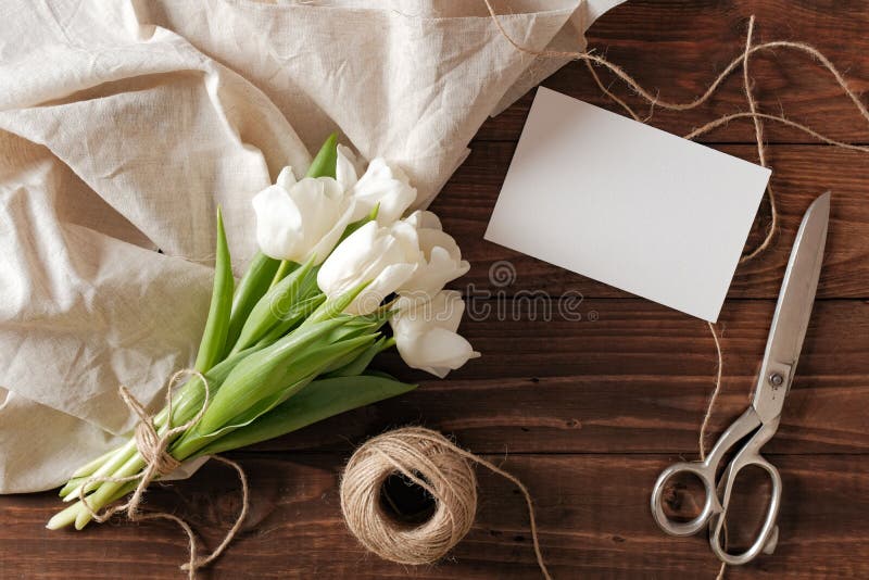 Tomt gifta sig inbjudankort och grupp av vårblommor på trätabellen Vita tulpan, textiltrasa, tvinnar, den romantiska gifta sig gr royaltyfria foton Tomt gifta sig inbjudankort och grupp av vårblommor på trätabellen Vita tulpan, textiltrasa, tvinnar, den romantiska gifta sig gr royaltyfria foton