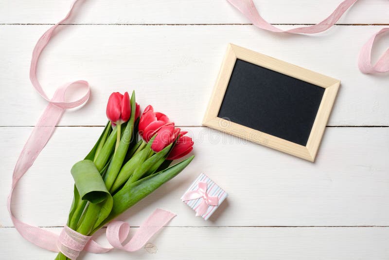 Tomt hälsa kort med röda tulpanblommor på den vita trätabellen Romantiskt gifta sig kort, hälsningkort för kvinna eller moderdag, royaltyfria bilder Tomt hälsa kort med röda tulpanblommor på den vita trätabellen Romantiskt gifta sig kort, hälsningkort för kvinna eller moderdag, royaltyfria bilder