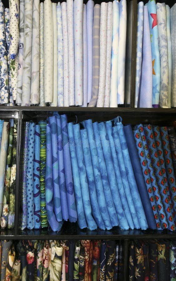 Variations of blue fat quarters stacked for sale; colors in various patterns and shades. Variations of blue fat quarters stacked for sale; colors in various patterns and shades