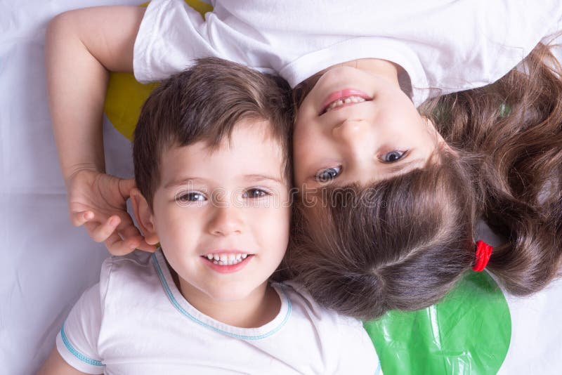 Toned photo. Background with happy kids. Boy and girl funny playing on color background.