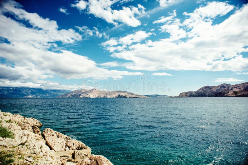 Scenic seaside landscape with cliffs and ocean waves, calm water and cloudy skies.Soft vintage effect on photo. Traveling concept. Scenic seaside landscape with cliffs and ocean waves, calm water and cloudy skies.Soft vintage effect on photo. Traveling concept