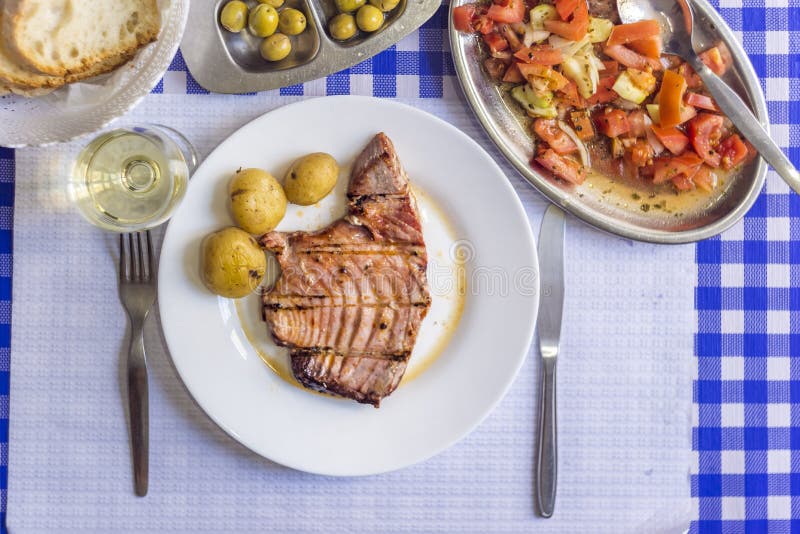 Tonfiskbiff som medföljs med potatisar, oliv, tomatsallad, brea royaltyfria bilder Tonfiskbiff som medföljs med potatisar, oliv, tomatsallad, brea royaltyfria bilder