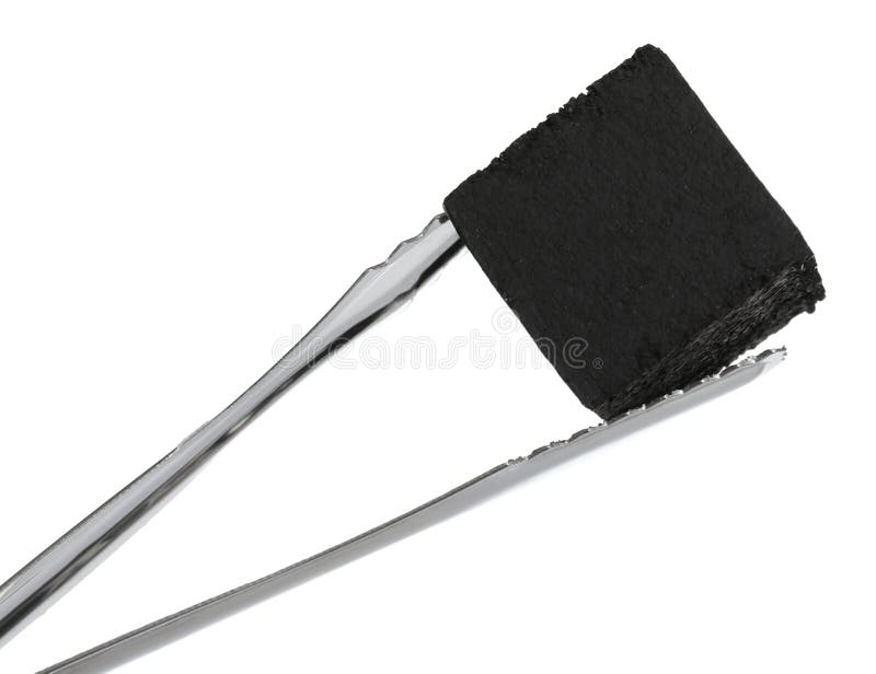 Tongs with charcoal cube for hookah on white background. Tongs with charcoal cube for hookah on white