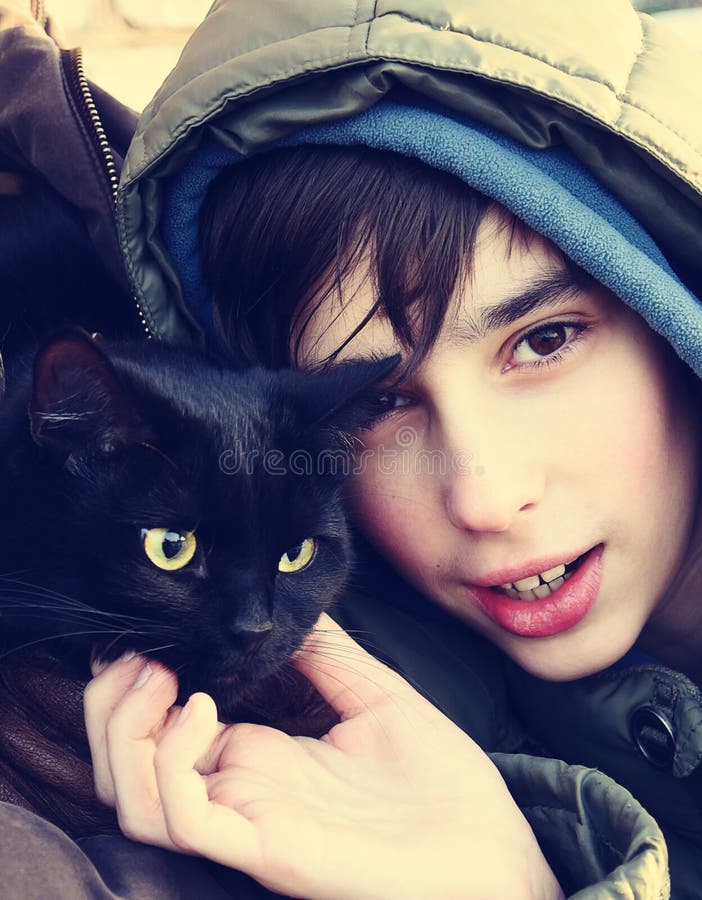 Tonårig pojke och svart katt royaltyfri fotografi Tonårig pojke och svart katt royaltyfri fotografi