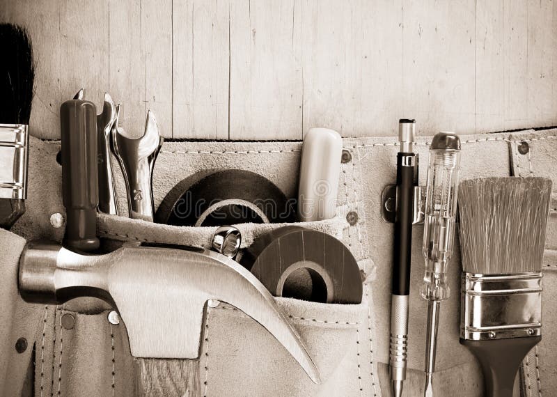 Tools in construction belt on wooden background