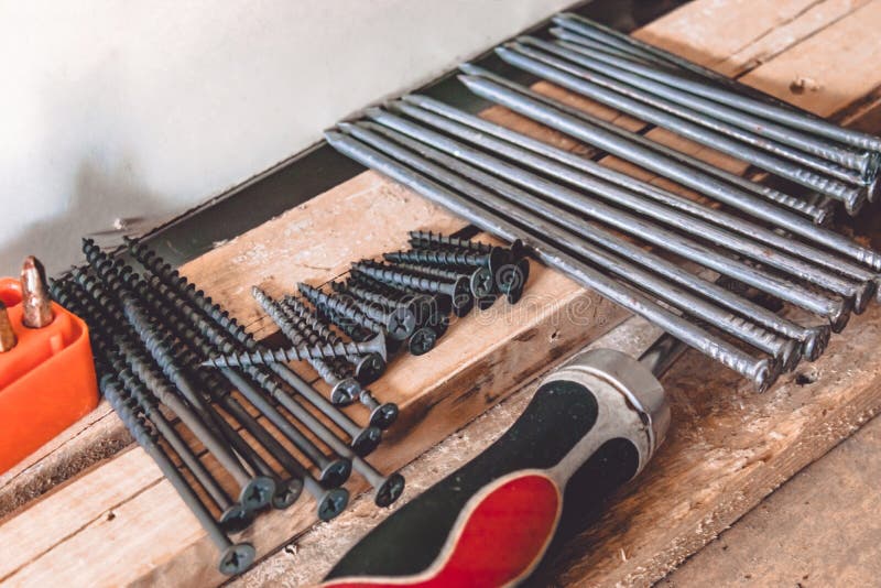 Tools for the Job. Screws, Nails and a Screwdriver are on the Table. Carpentry Tools Stock Photo