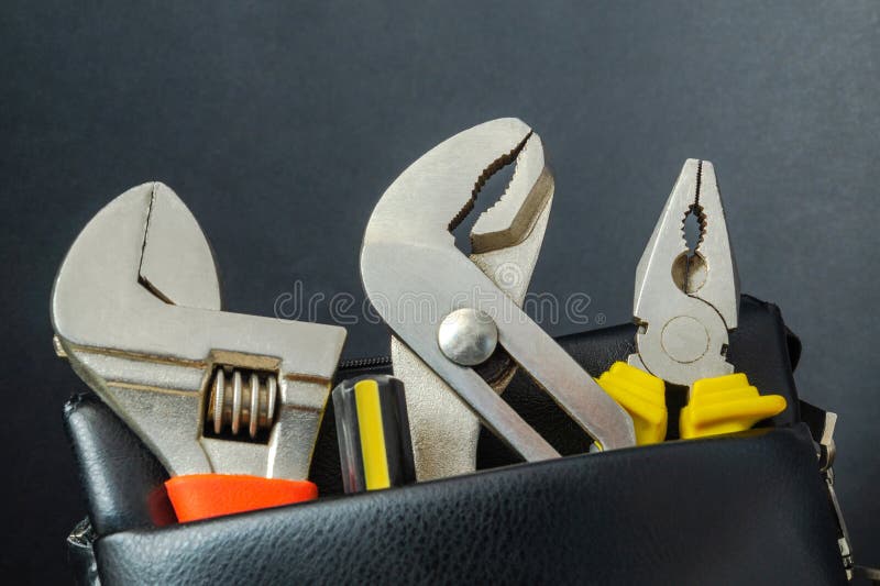 Tools in a leather bag on a black background - wrenches and pliers royalty free stock images Tools in a leather bag on a black background - wrenches and pliers royalty free stock images