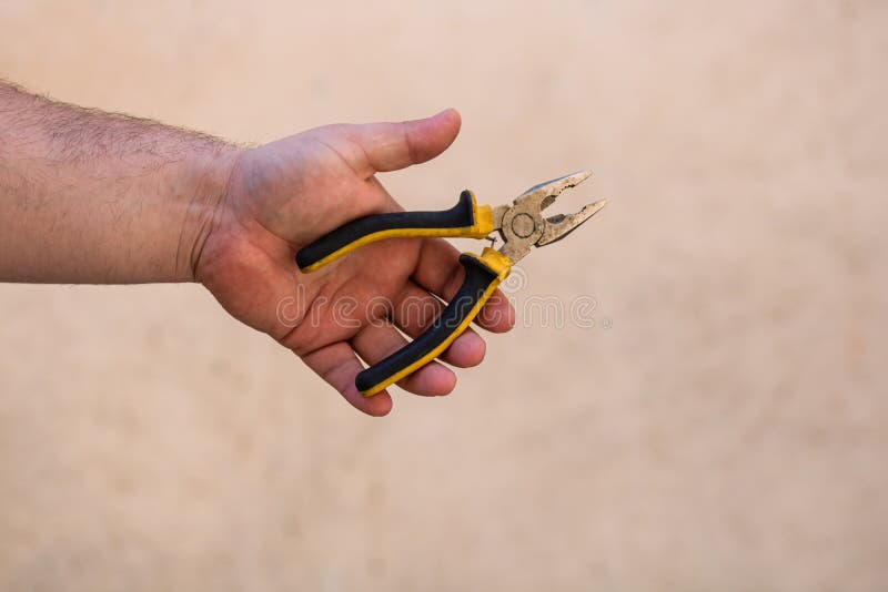 Tools for Repair and Building. Hand Holding Pliers on Blurred