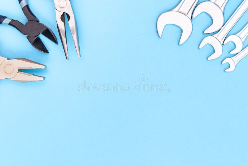 Tools worker, different pliers and many wrenchs on blue background, top view with free space stock images