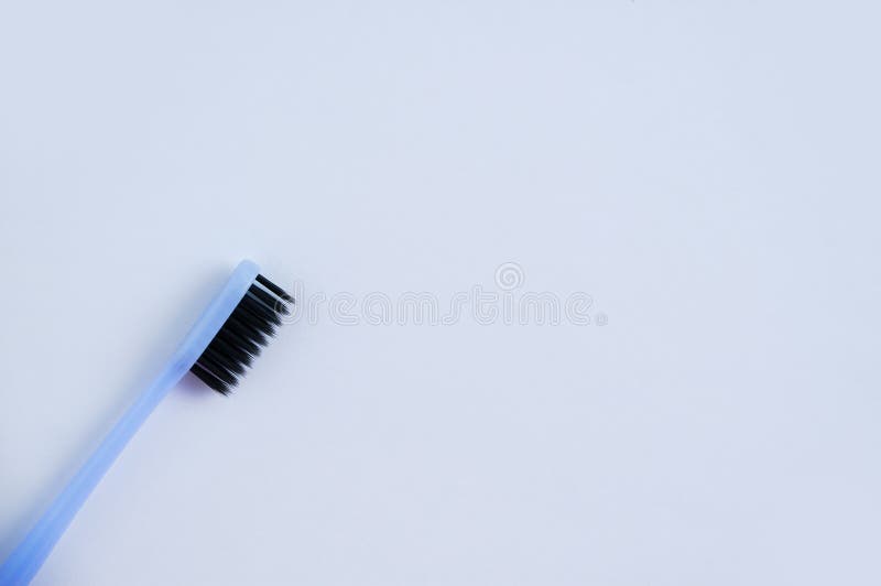 Toothbrush with Black Bristles on White Background. Place for Text