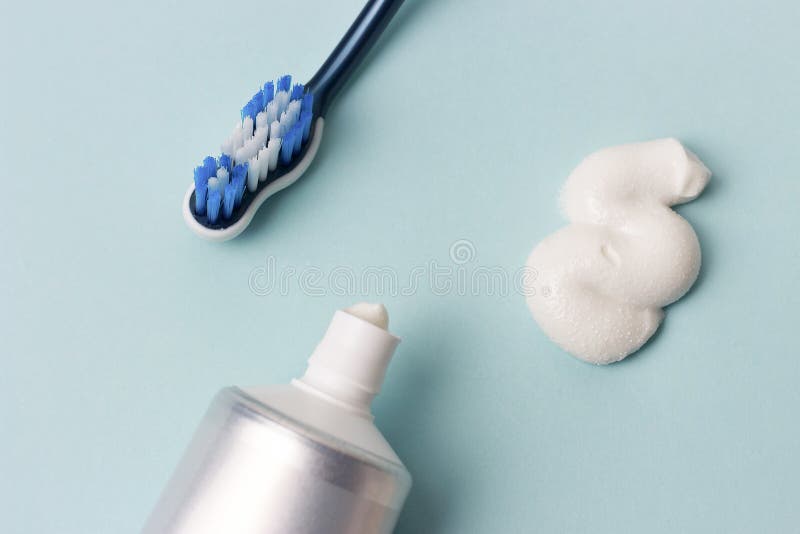 Toothpaste in Tube and Toothbrush on Blue Background. Dental Hygiene
