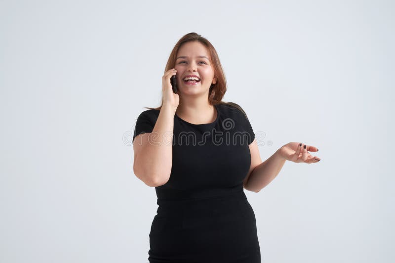 Toothy uśmiechnięta dziewczyna opowiada na telefonie przy studiiem fotografia royalty free Toothy uśmiechnięta dziewczyna opowiada na telefonie przy studiiem fotografia royalty free