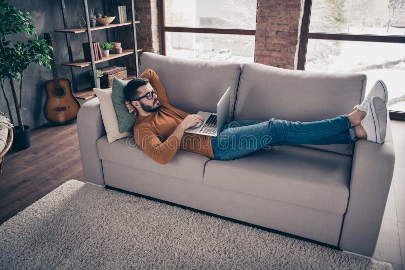 Top above high angle profile side view photo charming millennial youth lying divan feel focused have modern technology stock images