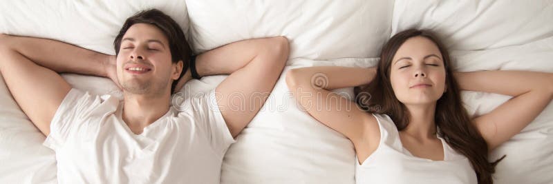 Top above horizontal image happy satisfied couple lying in bed stock image Top above horizontal image happy satisfied couple lying in bed stock image