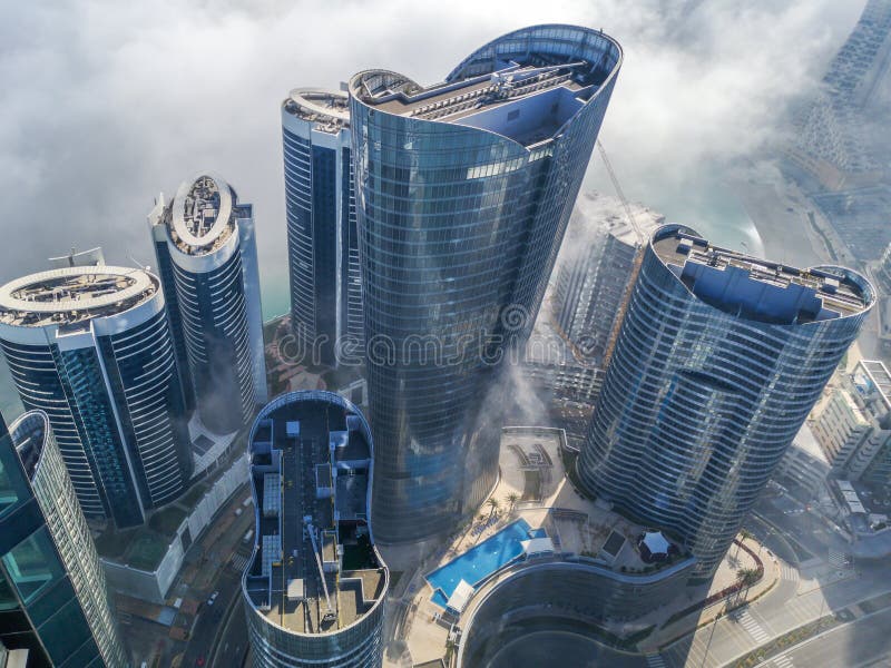 Top aerial view shot of skyscrapers in the city with fog clouds passing by - Abu Dhabi Al Reem island towers stock photography