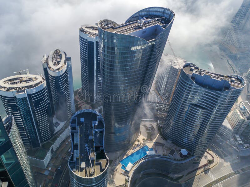 Top aerial view shot of skyscrapers in the city with fog clouds passing by - Abu Dhabi Al Reem island towers stock image