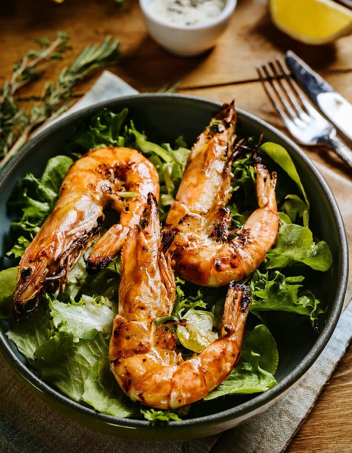 Top Aussicht auf frisch gegrillte Jumbo-Garnelen mit grünem Salat. Makro Top Aussicht auf frisch gegrillte Königengarnelen mit grü lizenzfreie abbildung