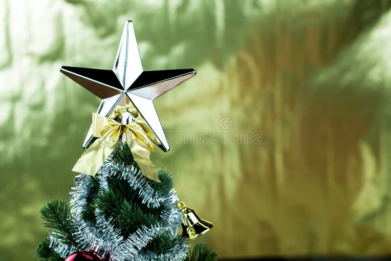 Top of Christmas Tree Decorated with Star in Bright Golden Shiny