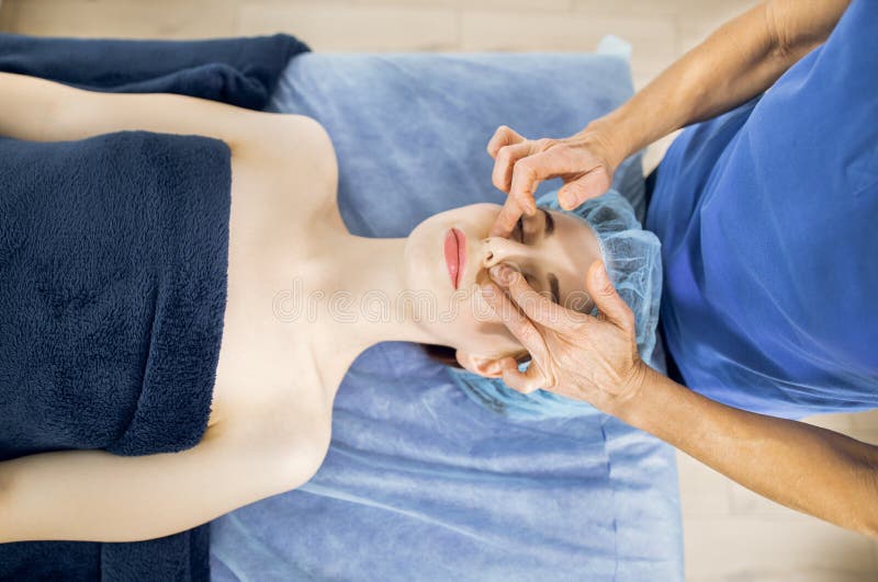 Top Close Up View Of Attractive Young Woman Enjoying Massage Spa Procedures For Face At Clinic