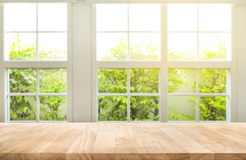 Top del contador de madera de la tabla en fondo del jardín de la opinión de la ventana de la falta de definición Top del contador de madera de la tabla en fondo del jardín de la opinión de la ventana de la falta de definición