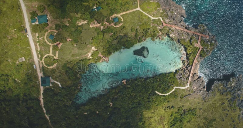 Top down of limpid turquoise lake with designed ways on green valley in aerial. Nobody Asia nature