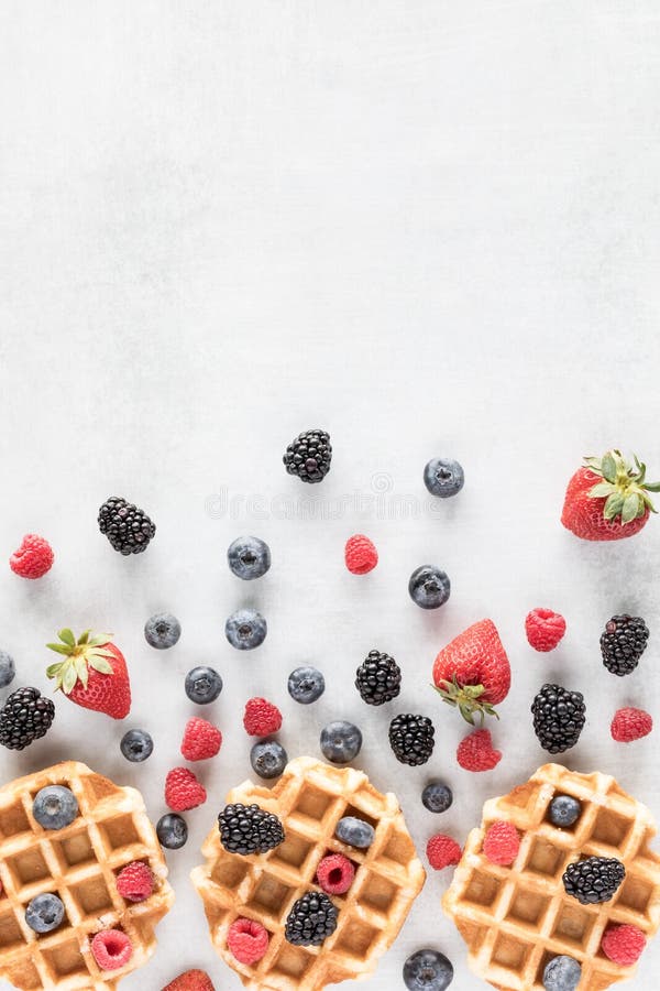 Top down view of Belgian waffles with berries in an abstract arrangement. stock photos