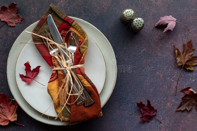 Top down view of a fall inspired table place setting against a dark background. royalty free stock images