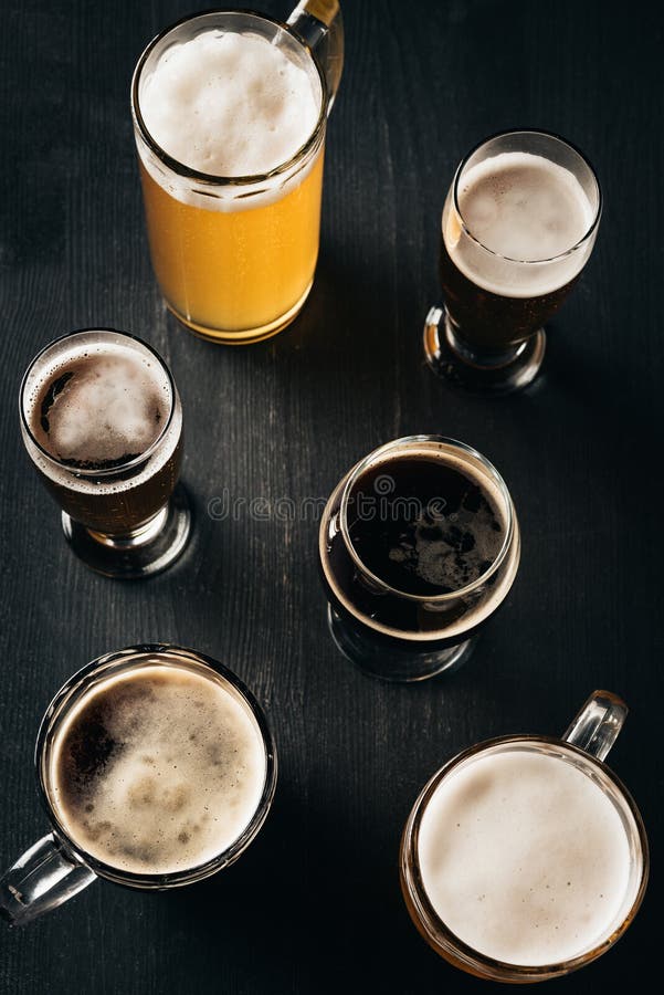 top view of arrangement of glasses of cold beer on dark royalty free stock photos