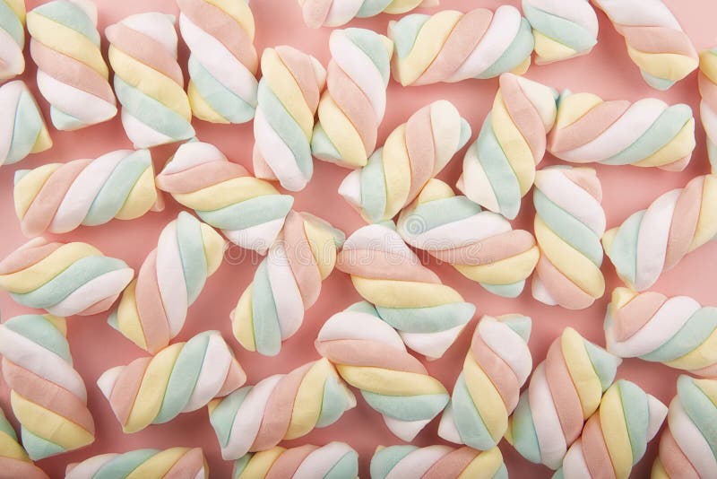 Top view on background texture of colorful twisted marshmallow candies.