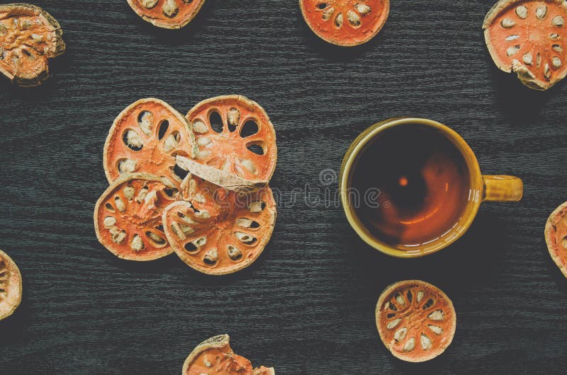 Top view of bael dry and glass tea and bael juice on the wooden floor stock photo Top view of bael dry and glass tea and bael juice on the wooden floor stock photo