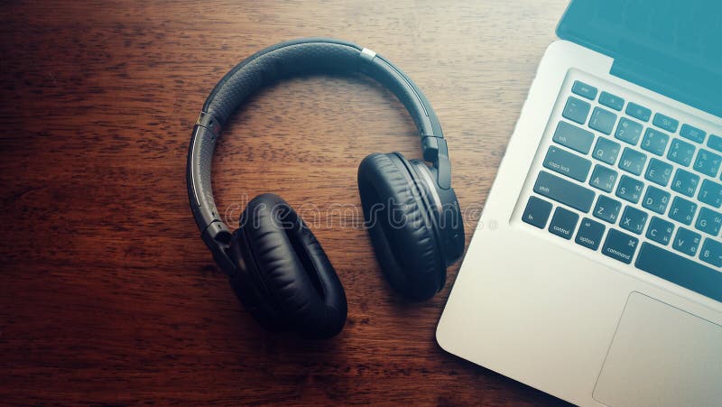 Top view of black bluetooth headphone with laptop computer. stock image