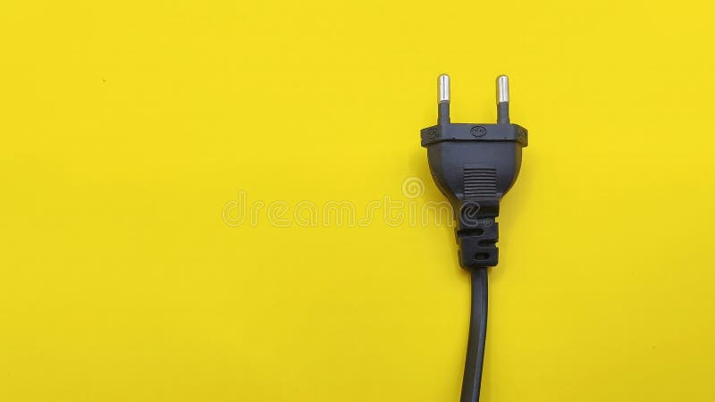 Top view of black electrical plug on yellow background. rules of thirds composition royalty free stock photos