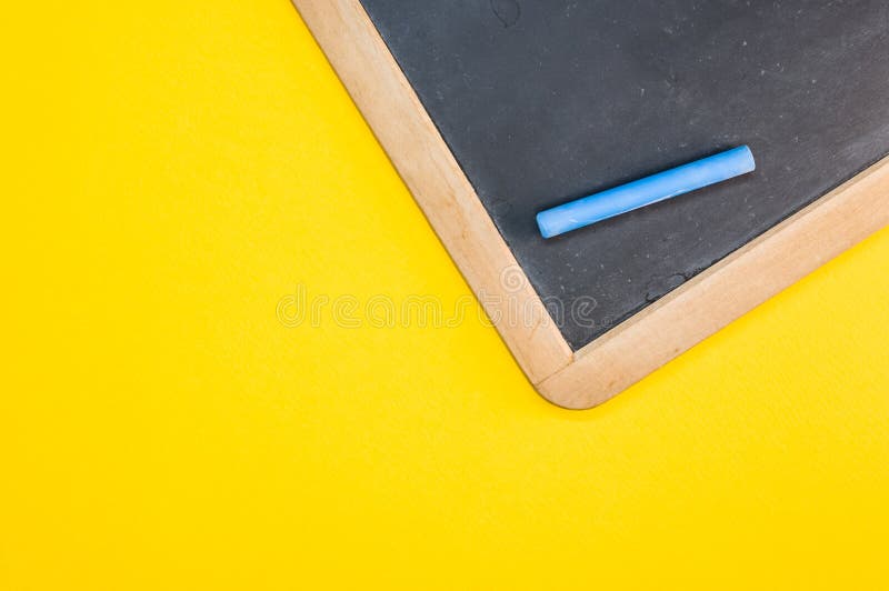 Top View of the Blackboard with Chalk on the Yellow Surface Stock Photo