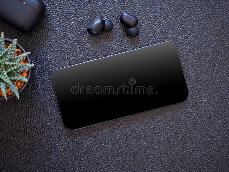Top view, blank black screen of smartphone and wireless earphone in-ear with charging case on black leather background.