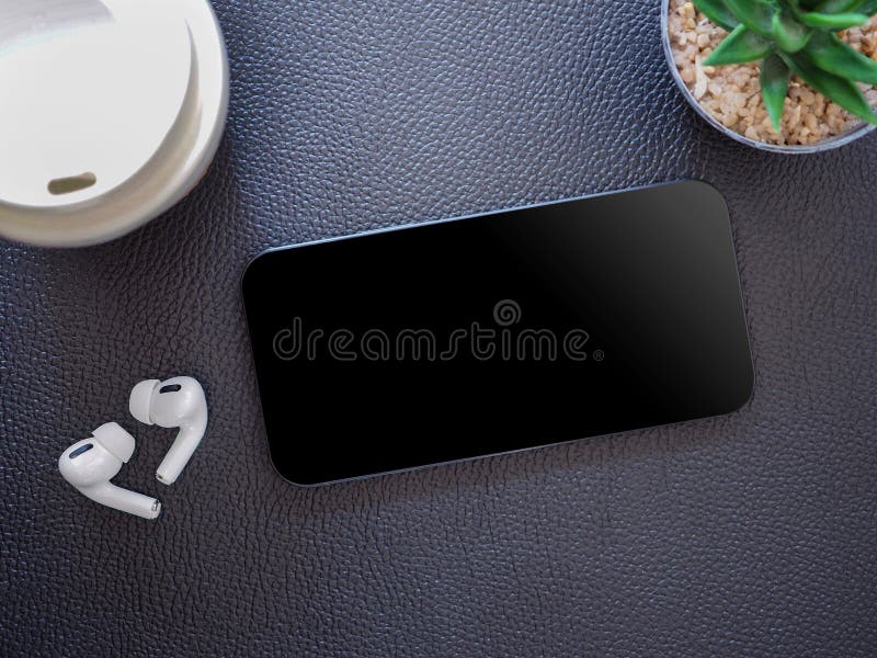 Top view, blank black screen of smartphone and wireless earphone in-ear with charging case on black leather background. Template, mock-up empty screen of