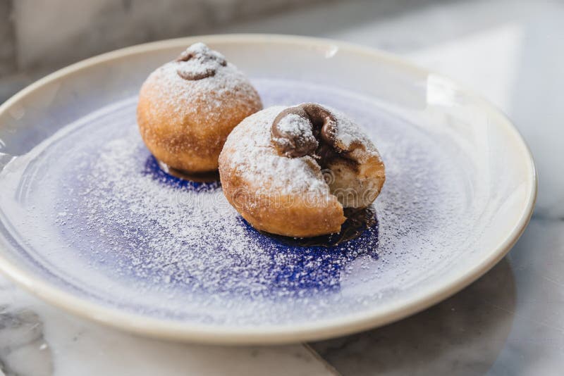 Top view of Bombolone is an Italian filled doughnut and is eaten as a snack food and dessert with hands cutting stock photography Top view of Bombolone is an Italian filled doughnut and is eaten as a snack food and dessert with hands cutting stock photography