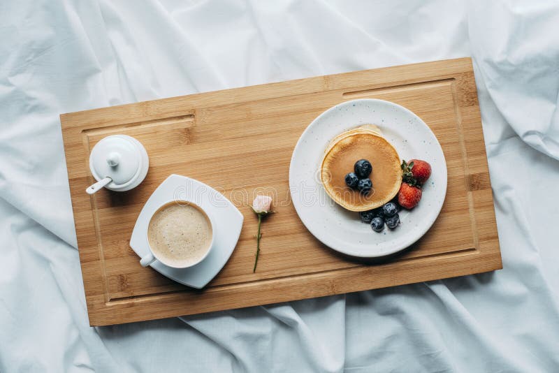 top view of breakfast in bed with tasty pancakes and coffee stock photo