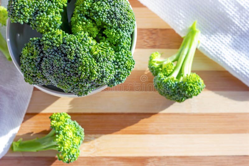 Top view of bright green organic raw broccoli branches in the white bowl on the table in the kitchen close up with copy space. royalty free stock images Top view of bright green organic raw broccoli branches in the white bowl on the table in the kitchen close up with copy space. royalty free stock images