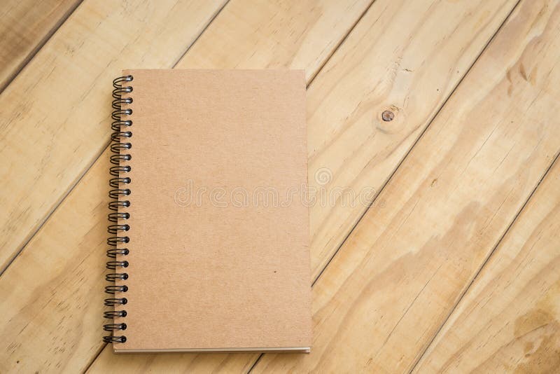 Top view of brown book on wooden table. Author, letterhead.