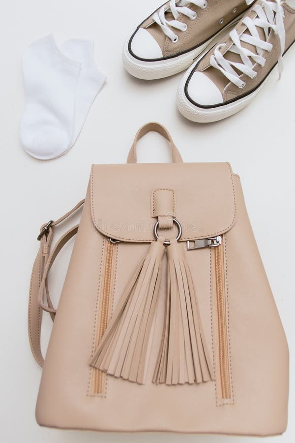 Top view on brown sneakers, beige backpack, white socks on pastel background stock photo Top view on brown sneakers, beige backpack, white socks on pastel background stock photo