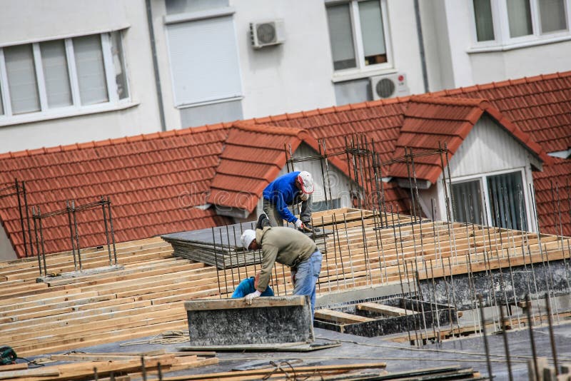 Builders that Works on the Construction Site with Hammer Editorial