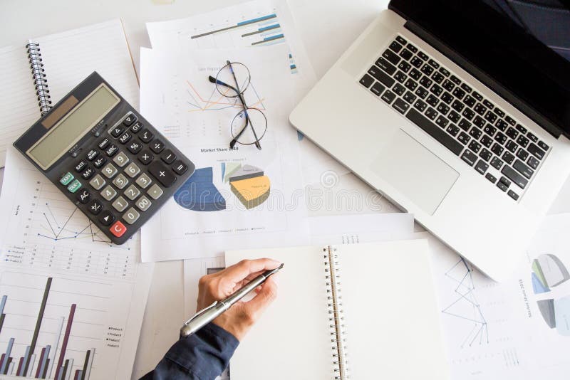 Top view , Business man left hand holding pen writing report stock photos