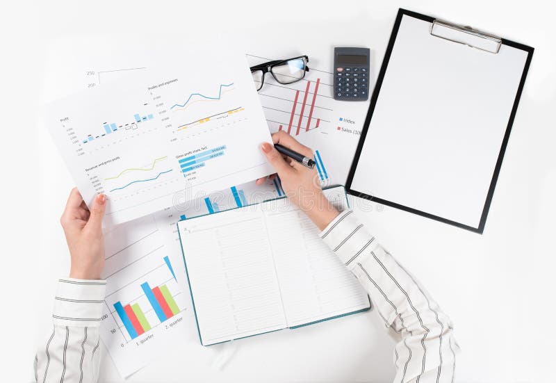 Top view of business woman`s hands analyzes the charts on white table royalty free stock image Top view of business woman`s hands analyzes the charts on white table royalty free stock image