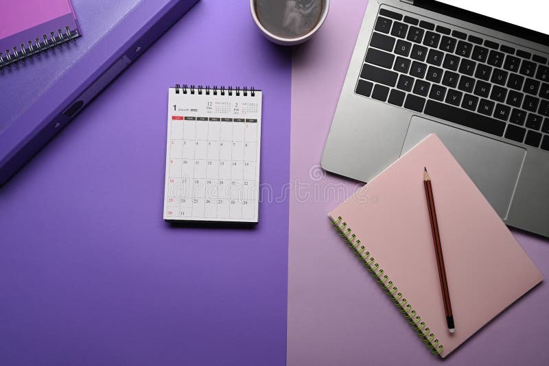 Calendar, Notebook Ad Laptop Computer on Purple Background. Stock Photo