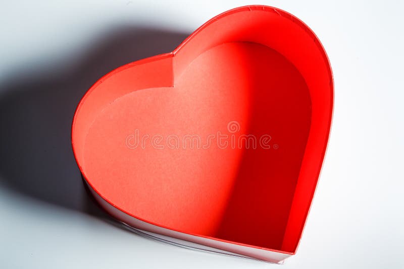 Top view closeup on empty red cardboard heart shaped box on grey surface. Top view closeup on empty red cardboard handmade heart shaped box served on grey table surface background