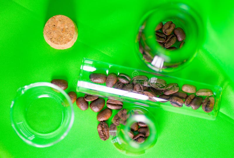 Top View of Coffee Beans in Laboratory Glassware on a Green Table Stock
