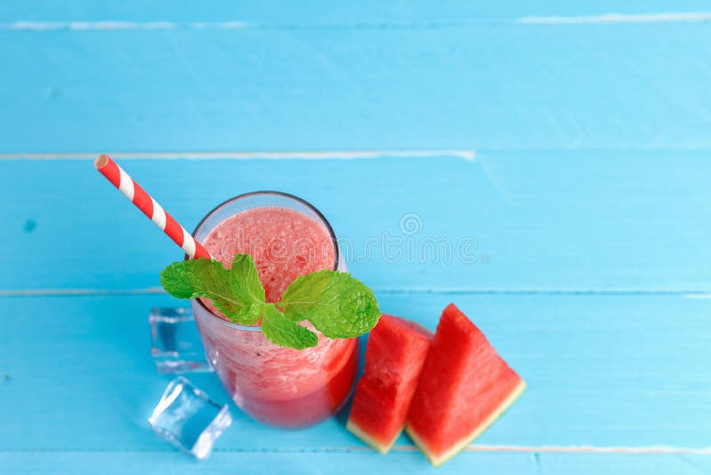 Top view cold watermelon juice in the glass on old blue wooden table