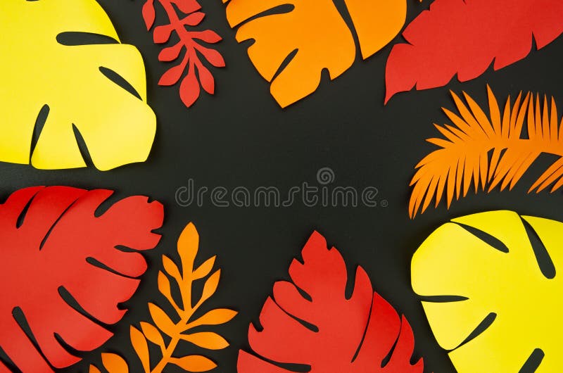 Top view Colorful Red, Yellow and Orange Paper palm leaves frame on black background. Summer concept with copy space.