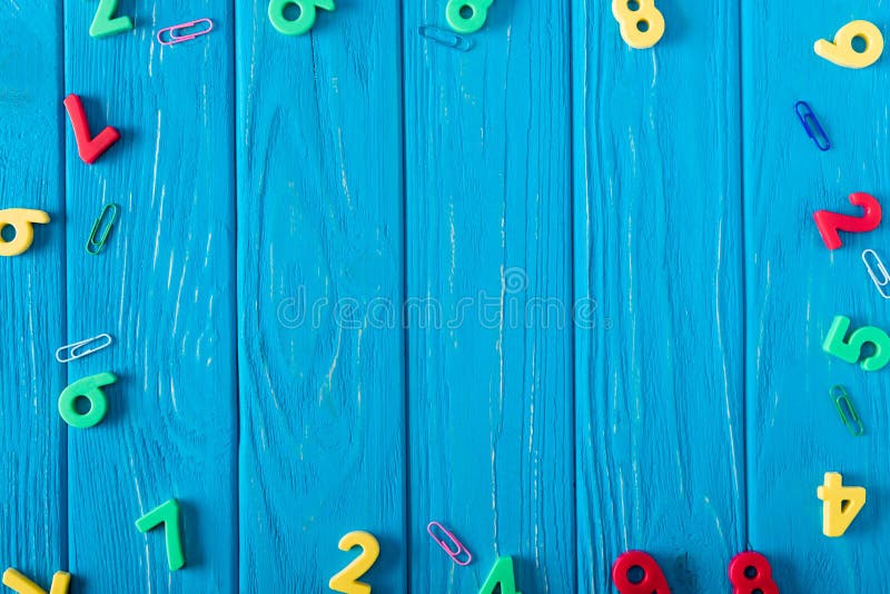 top view of colorful various numbers and paper clips on blue wooden